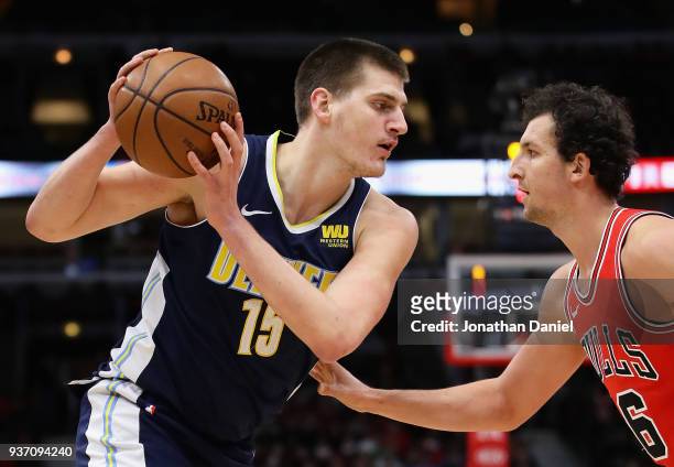 Nikola Jokic of the Denver Nuggets moves against Paul Zipser of the Chicago Bulls at the United Center on March 21, 2018 in Chicago, Illinois. The...