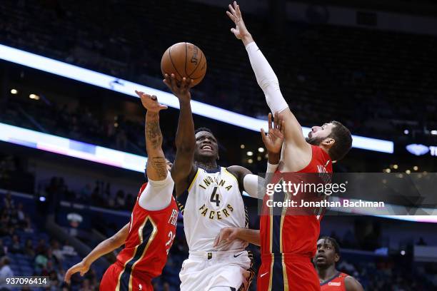 Victor Oladipo of the Indiana Pacers shoots against Nikola Mirotic of the New Orleans Pelicans and Anthony Davis during the second half at the...