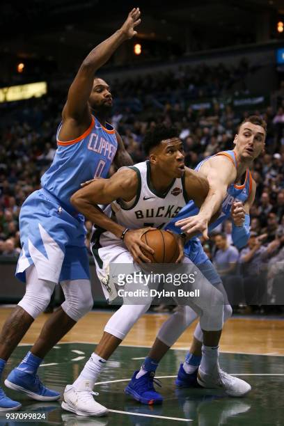 Giannis Antetokounmpo of the Milwaukee Bucks handles the ball between Sindarius Thornwell and Sam Dekker of the Los Angeles Clippers in the second...