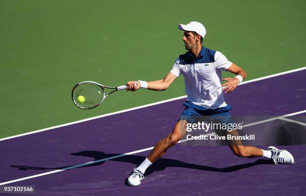 Novak Djokovic of Serbia plays a forehand volley against Benoit Paire of France in their second round match during the Miami Open Presented by Itau...