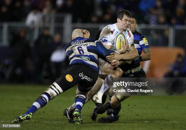 Ian Whitten of Exeter Chiefs is tackled by Matt Garvey and Charlie Ewels of Bath during the Aviva Premiership match between Bath Rugby and Exeter...