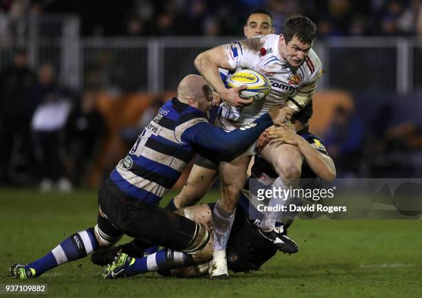 Ian Whitten of Exeter Chiefs is tackled by Matt Garvey and Charlie Ewels of Bath during the Aviva Premiership match between Bath Rugby and Exeter...