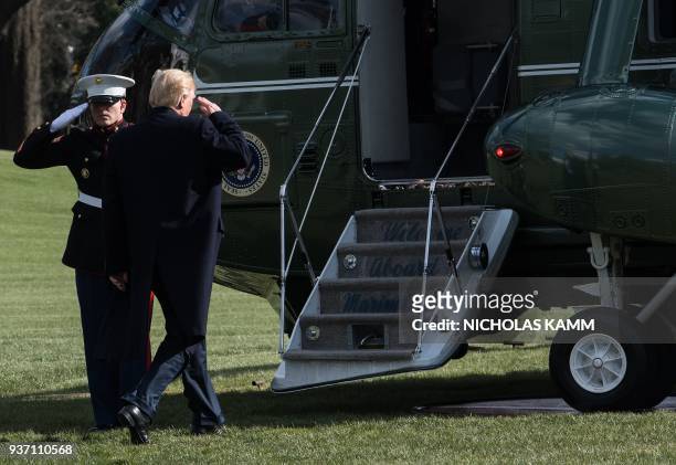 President Donald Trump salutes as he boards Marine One to depart the White House towards in Washington, DC on March 23, 2018 heading to Andrews Air...