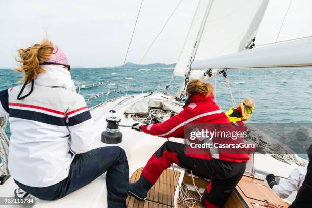 femme tire sur la corde sur le cours de voile - poulie photos et images de collection