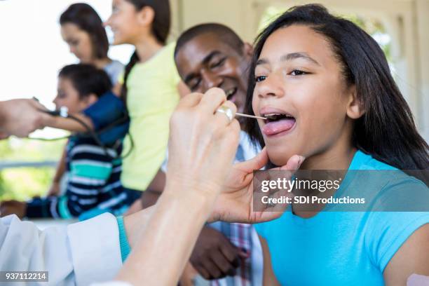 young girl receives medical exam at free clinic - film and television screening stock pictures, royalty-free photos & images