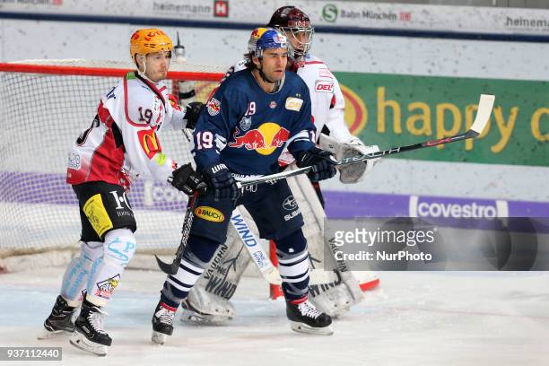 Marian Dejdar of Pinguins Bremerhaven vies Jon Matsumoto of Red Bull Munich in front of Tomas Poepperle of Pinguins Bremerhaven during the DEL...
