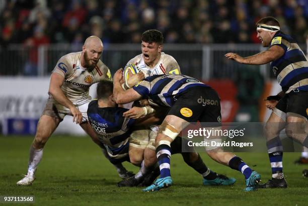 Dave Ewers of Exeter Chiefs is tackled by Elliott Stooke and Tom Ellis of Bath during the Aviva Premiership match between Bath Rugby and Exeter...