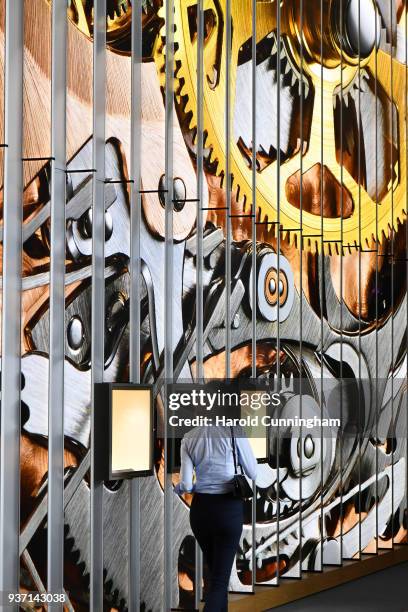 Visitor walks by a watch movement display on the Blancpain booth at the BaselWolrd watch fair on March 23, 2018 in Basel, Switzerland. The annual...