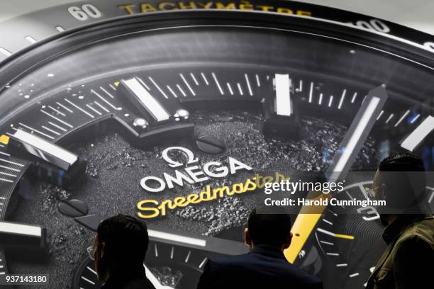 Visitors look at an Omega watch display on the Blancpain booth at the BaselWolrd watch fair on March 23, 2018 in Basel, Switzerland. The annual watch...