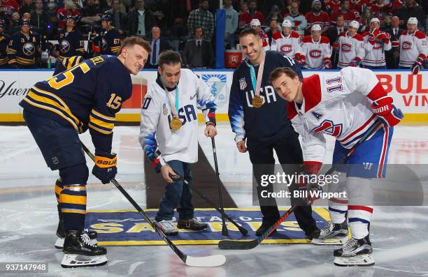 Paralympic Sled Hockey Gold Medalists Adam Page and Luke McDermott take part in a ceremonial puck drop between Jack Eichel of the Buffalo Sabres and...