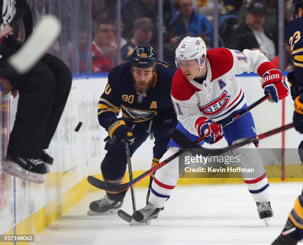 Ryan O'Reilly of the Buffalo Sabres and Brendan Gallagher of the Montreal Canadiens go after a puck on the boards during the first period at KeyBank...