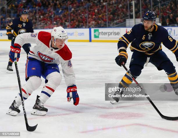 Daniel Carr of the Montreal Canadiens tries to skate around Marco Scandella of the Buffalo Sabres with the puck during the first period at KeyBank...