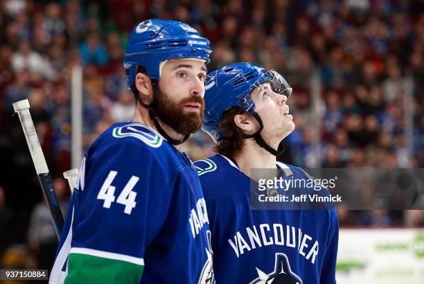 Ben Hutton and Erik Gudbranson of the Vancouver Canucks look on from the bench during their NHL game against the New York Islanders at Rogers Arena...