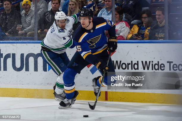 Colton Parayko of the St. Louis Blues skates with the puck as Michael Del Zotto of the Vancouver Canucks pressures at Scottrade Center on March 23,...