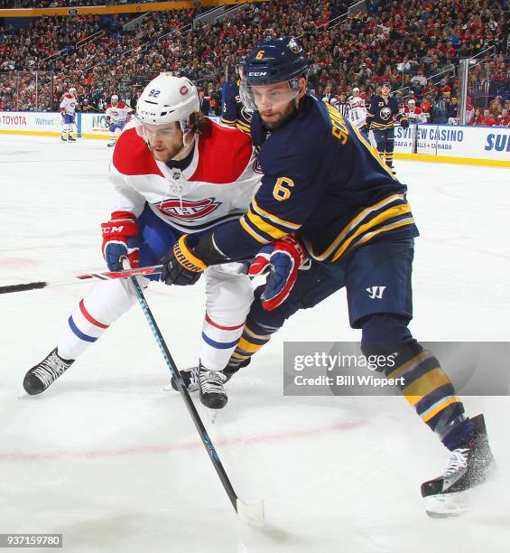 Jonathan Drouin of the Montreal Canadiens and Marco Scandella of the Buffalo Sabres battle for the puck along the boards during an NHL game on March...