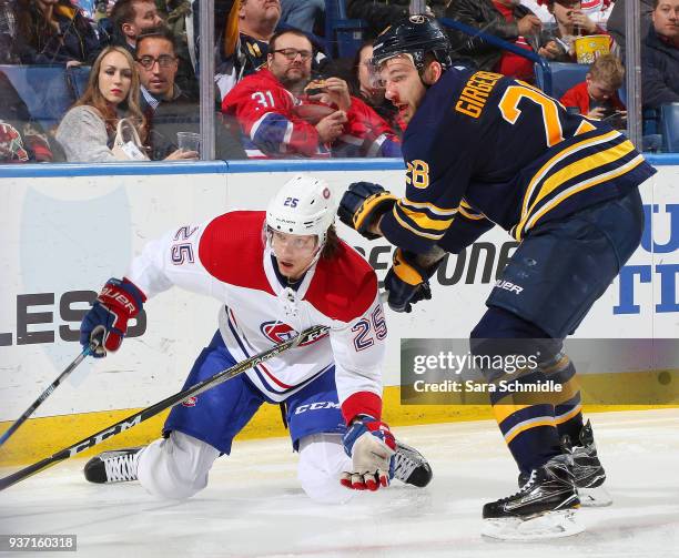 Zemgus Girgensons of the Buffalo Sabres and Jacob de la Rose of the Montreal Canadiens collide along the boards during an NHL game on March 23, 2018...