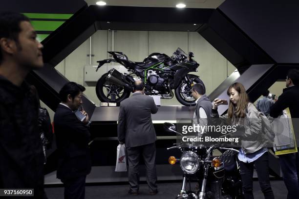 Attendees look at a Kawasaki Heavy Industries Ltd. Ninja H2 Carbon motorcycle, center, on display at the Tokyo Motorcycle Show in Tokyo, Japan, on...