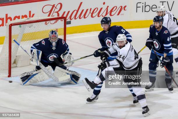 Tyler Myers of the Winnipeg Jets and Nate Thompson of the Los Angeles Kings battles in front of goaltender Eric Comrie as they keep an eye on the...