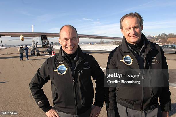 Bertrand Piccard, left, and Andre Borschberg, co-founders of the Solar Impulse project, pose in front of the Solar Impulse HB-SIA airplane at...