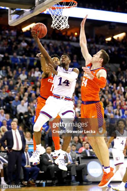 Malik Newman of the Kansas Jayhawks attempts a layup defended by Elijah Thomas and David Skara of the Clemson Tigers during the second half in the...