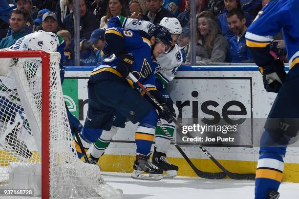 Ivan Barbashev of the St. Louis Blues and Darren Archibald of the Vancouver Canucks battle for the puck at Scottrade Center on March 23, 2018 in St....