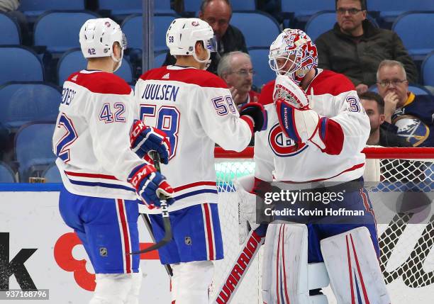 Antti Niemi of the Montreal Canadiens is congratulated by Noah Juulsen and Byron Froese after beating the Buffalo Sabres at KeyBank Center on March...