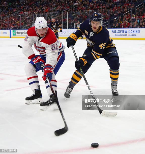 Artturi Lehkonen of the Montreal Canadiens and Brendan Guhle of the Buffalo Sabres go after a loose puck during the third period at KeyBank Center on...