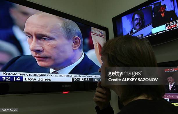 Russian Prime Minister Vladimir Putin is seen speaking on a television set at an electronics store during his annual televised phone-in show in...