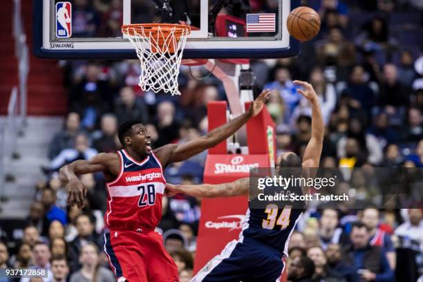 Ian Mahinmi of the Washington Wizards defends Devin Harris of the Denver Nuggets during the second half at Capital One Arena on March 23, 2018 in...