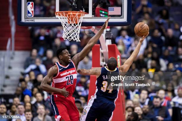 Ian Mahinmi of the Washington Wizards defends Devin Harris of the Denver Nuggets during the second half at Capital One Arena on March 23, 2018 in...