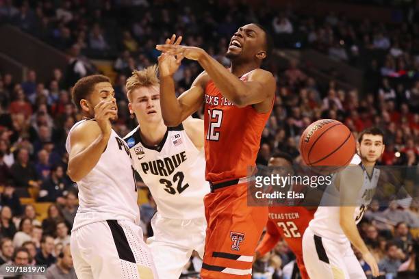 Keenan Evans of the Texas Tech Red Raiders loses the ball as he drives to the basket against P.J. Thompson and Matt Haarms of the Purdue Boilermakers...