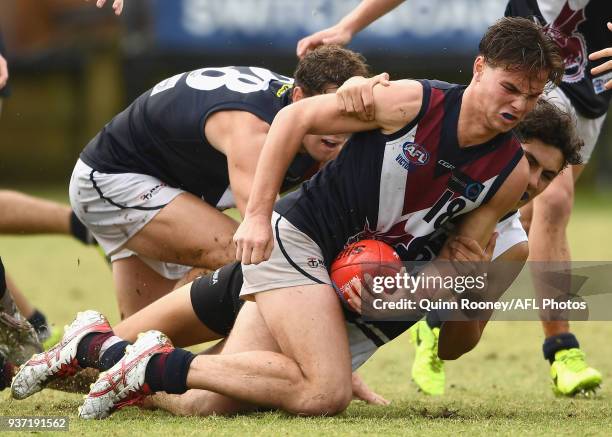 Anthony Seaton of the Dragons handballs whilst being tackled during the round one TAC Cup match between Northern Knights and Sandringham at Frankston...