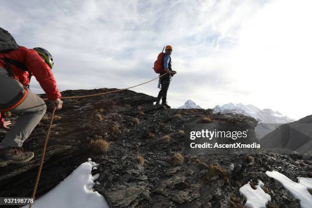 alpinista donna sale in vetta belay - messa in sicurezza foto e immagini stock