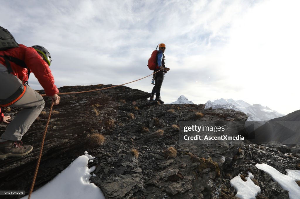 Female mountaineer climbs to summit belay