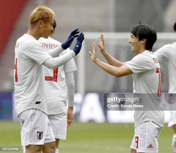 Shoya Nakajima is congratulated by Japan teammate Keisuke Honda after scoring a last-minute equalizer to earn a 1-1 draw with Mali in a football...