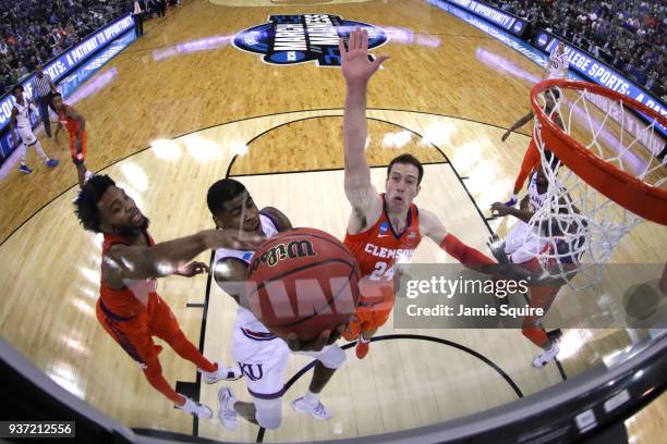 Malik Newman of the Kansas Jayhawks attempts a shot against Gabe DeVoe and David Skara of the Clemson Tigers in the 2018 NCAA Men's Basketball...