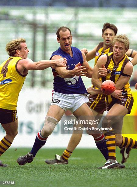 Rayden Tallis and Chris Obst for Hawthorn and Matthew Croft for the Bulldogs compete for the ball during the round 20 AFL match played between the...