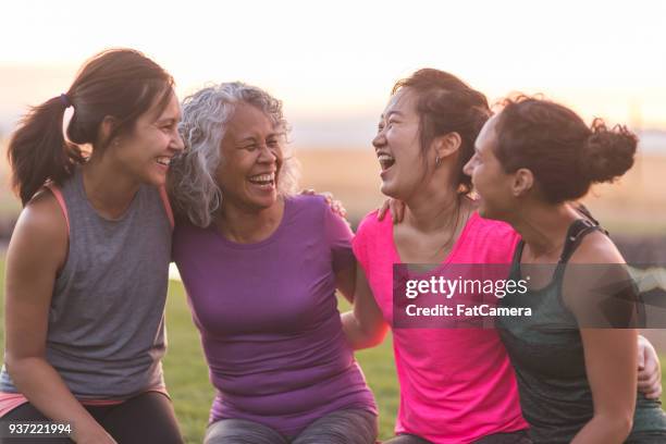 fyra etniska kvinnor skrattar tillsammans efter en utomhus träning - yoga group bildbanksfoton och bilder