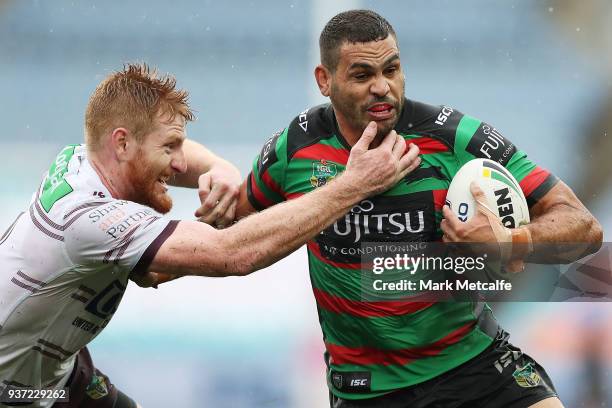Greg Inglis of the Rabbitohs hands off Brad Parker of the Sea Eagles during the round three NRL match between the South Sydney Rabbitohs and the...