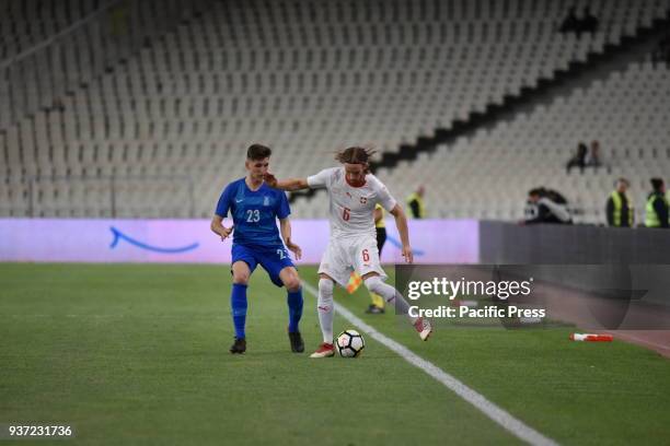 Michael Lang of Switzerland tries to pass the ball from Panagiotis Retsos of Greece. Switzerland won against Greece with final score of 1-0.