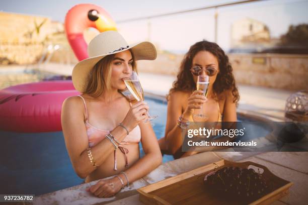 young women on luxurious holidays drinking champagne in the pool - hot tub party stock pictures, royalty-free photos & images
