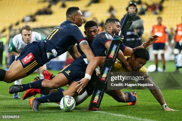 Ben Lam of the Hurricanes scores a try in the tackle of Lima Sopoaga, Tevita Li and Waisake Naholo of the Highlanders during the round six Super...