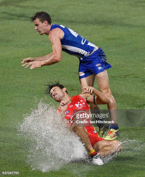 Lachie Weller of the Suns is tackled by Kayne Turner of the Kangaroos during the round one AFL match between the Gold Coast Suns and the North...