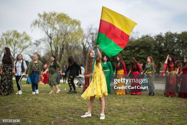 Young girl waves the flag of the Democratic Federation of Northern Syria during Nowruz celebrations on March 24, 2018 in Tokyo, Japan. Nowruz meaning...