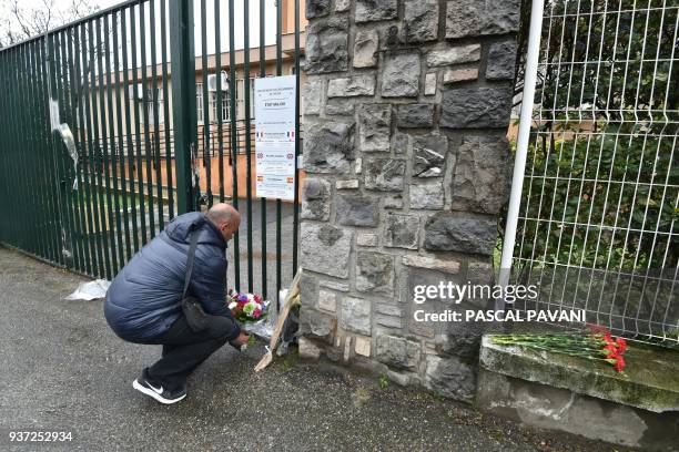 Man lays flowers in front of the Gendarmerie Nationale in Carcassonne on March 24, 2018 in tribute to the gendarme killed after swapping himself for...