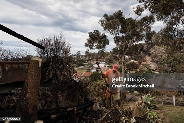 Richard Galton works to repair bushfire damage in the backayrd of his Tathra home on March 24, 2018 in Tathra, Australia. Ricard stayed to defend his...