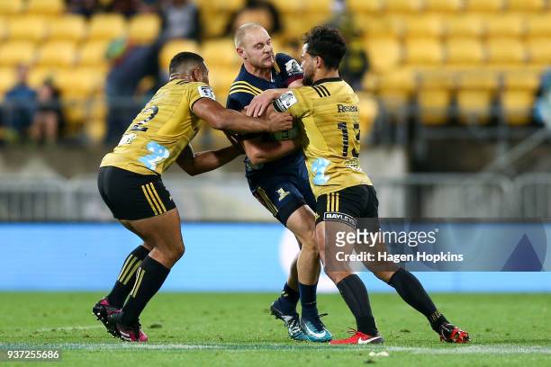 Matt Faddes of the Highlanders is tackled by Matt Proctor and Ngani Laumape of the Hurricanes during the round six Super Rugby match between the...