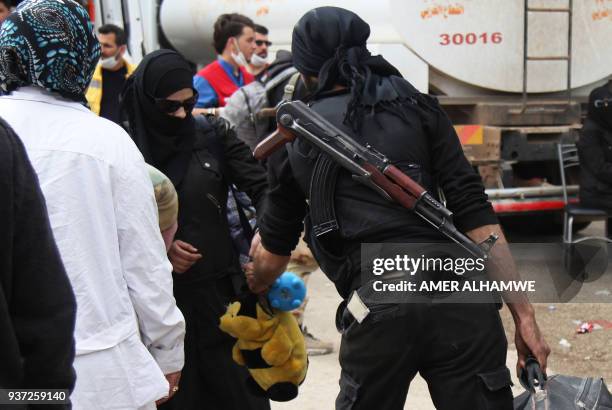 Syrian civilians and rebel fighters arrive in the village Mizanz, some 30 kilometres northeast of Idlib on March 24, 2018 after being evacuated from...