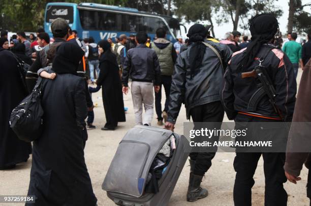 Syrian civilians and rebel fighters arrive in the village Mizanz, some 30 kilometres northeast of Idlib on March 24, 2018 after being evacuated from...