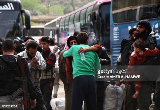 Syrian civilians and rebel fighters arrive in the village Mizanz, some 30 kilometres northeast of Idlib on March 24, 2018 after being evacuated from...
